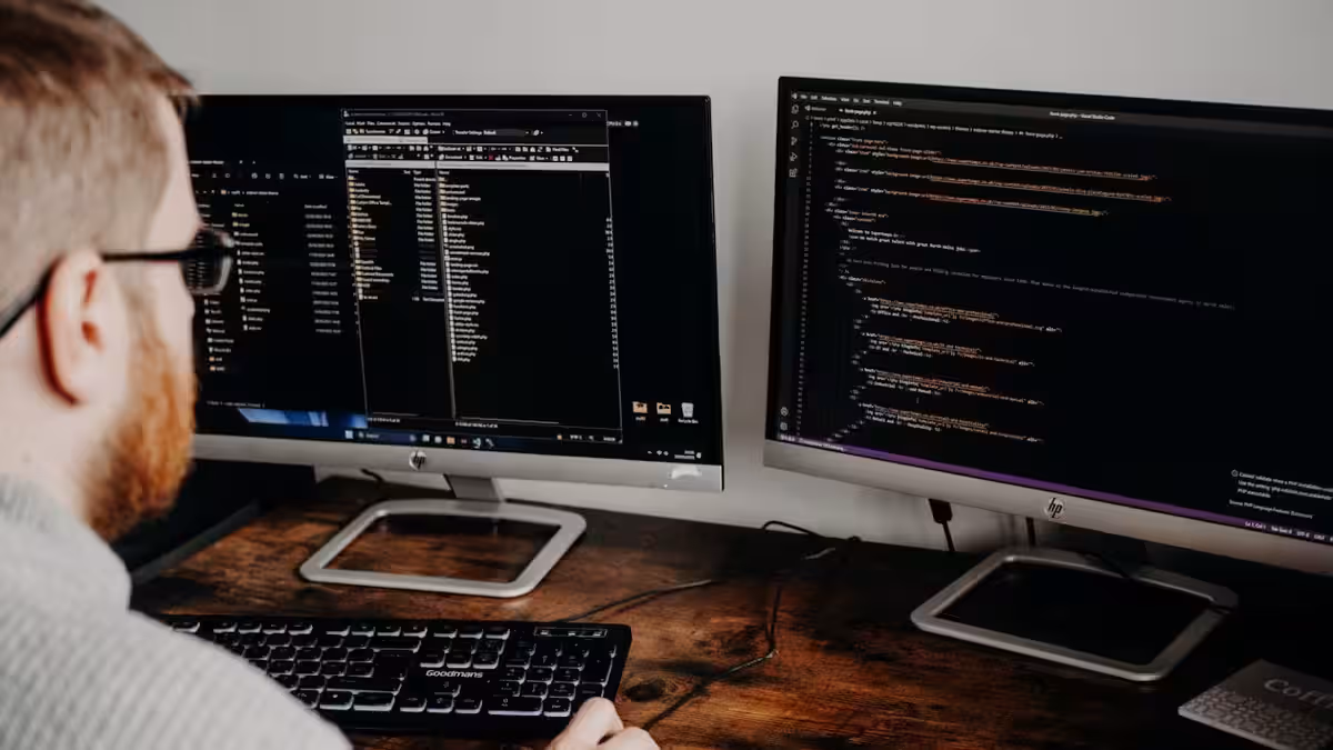 Geschäftsperson und Webentwickler im Gespräch über ein Laptop , Qualitätskriterien für die Auswahl eines guten Webentwicklers