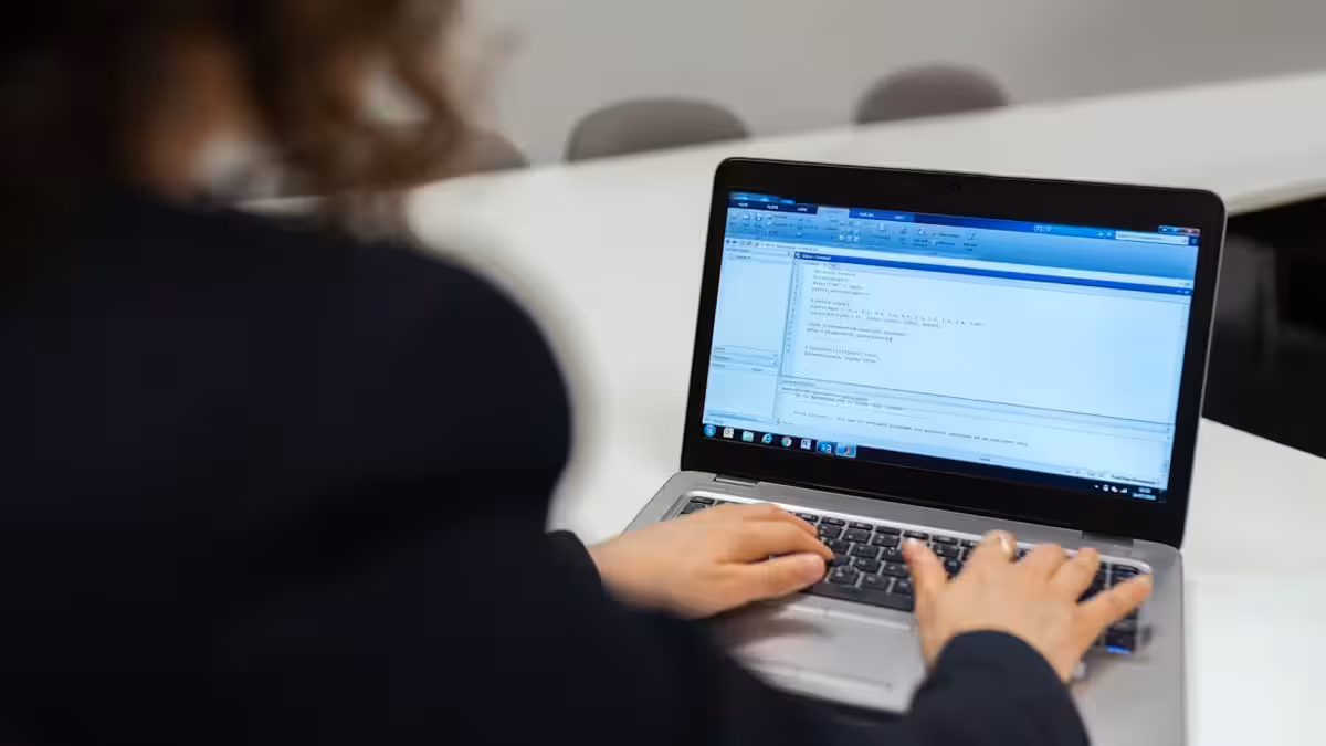 Person am Laptop baut eine Webseite mit Baukasten-Tool , Entscheidungshilfe zwischen DIY und professioneller Webentwicklung